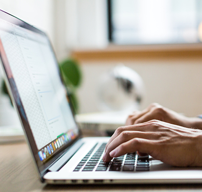 Side view of person typing on a laptop computer