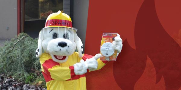 Fire Mascot Sparky holding a smoke detector