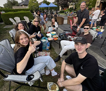 A photo of smiling people sitting on lawn chairs from the Creekstone Neighbourhood Block Party for Neighbourhood Grant project in 2025